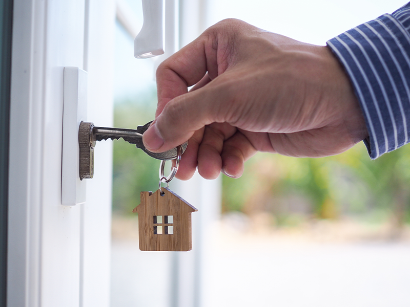 Entering a key with a keychain that looks like a house into a door